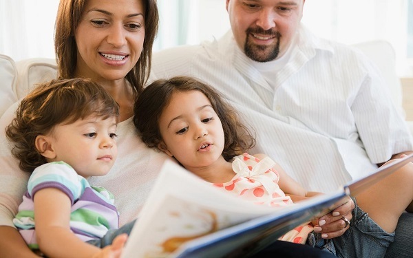Family reading together: mom, dad, 2 children