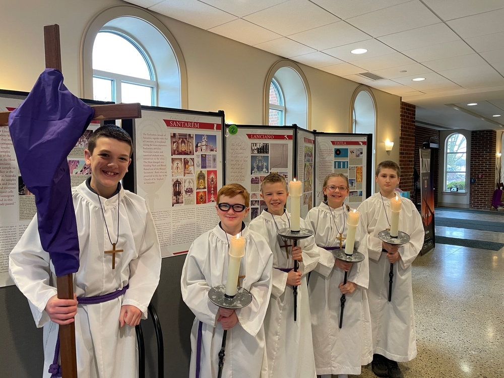 photo of 5 altar servers with cross and candles
