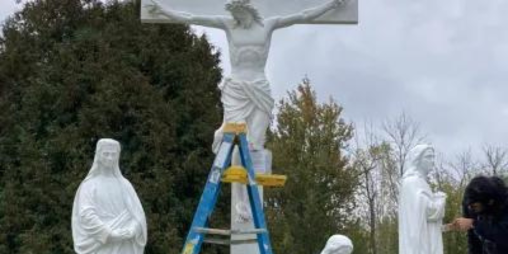 statues of the crucifixion with a ladder in front of them