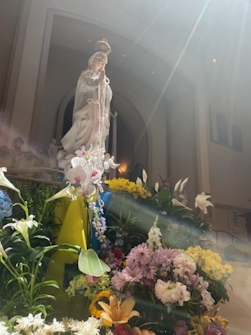 statue of Mary surrounded by flowers
